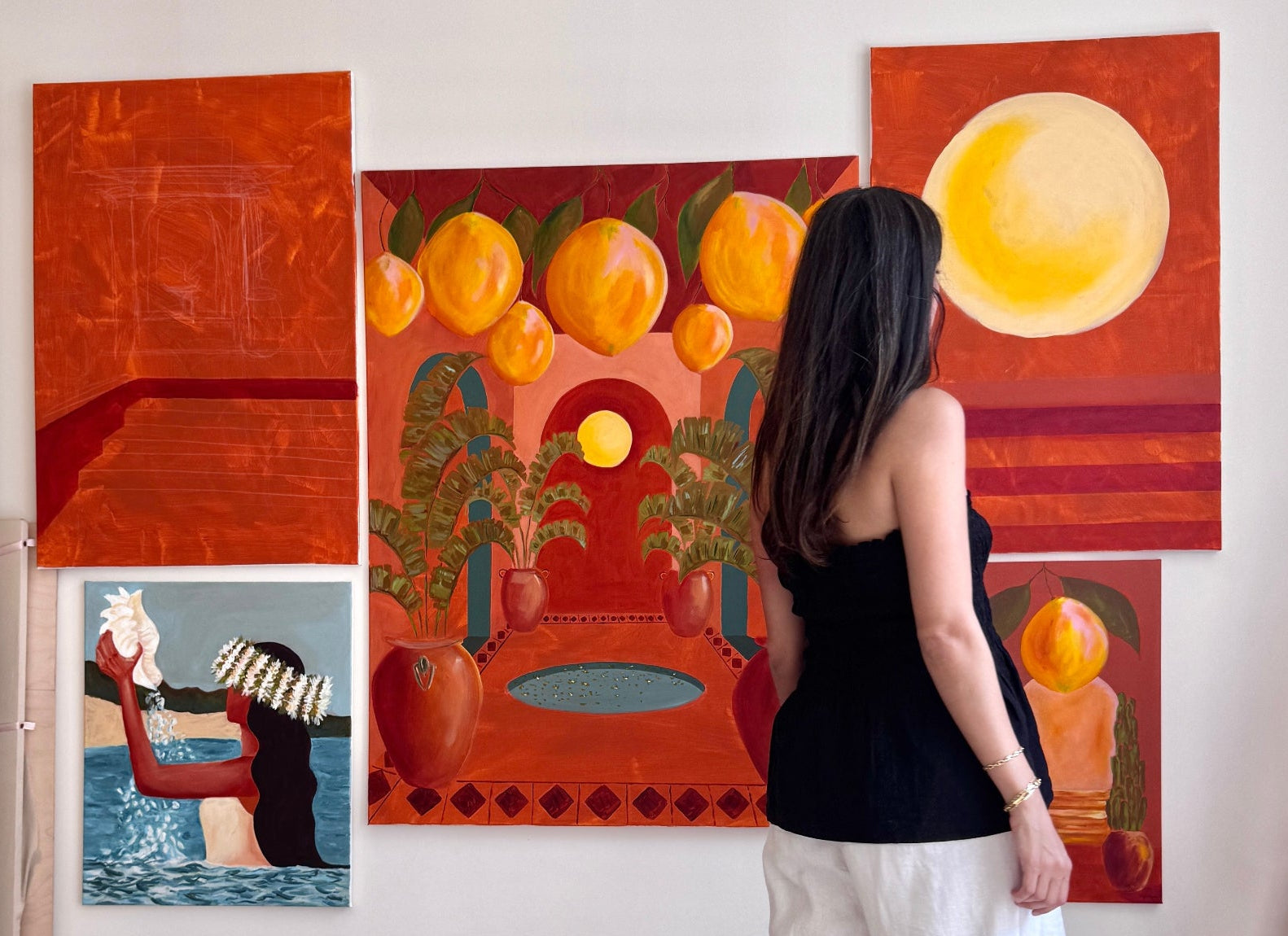 Woman standing in front of a wall with colorful abstract paintings